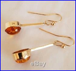An antique pair of 9ct Yellow gold drop earrings. Set with oval Baltic Amber